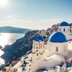 Churches in Oia, Santorini island in Greece, on a sunny day. Panorama view. | Von Funny Studio